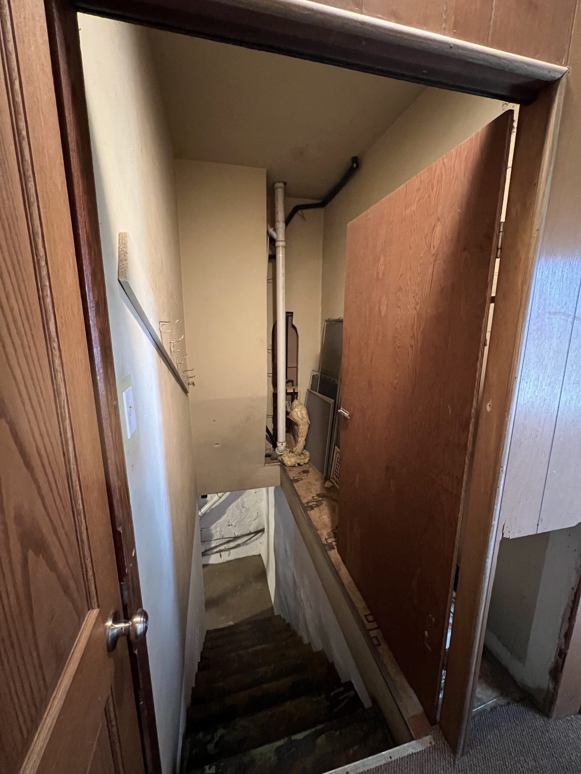 basement-stairwell-exposed-plumbing-linoleum-removal